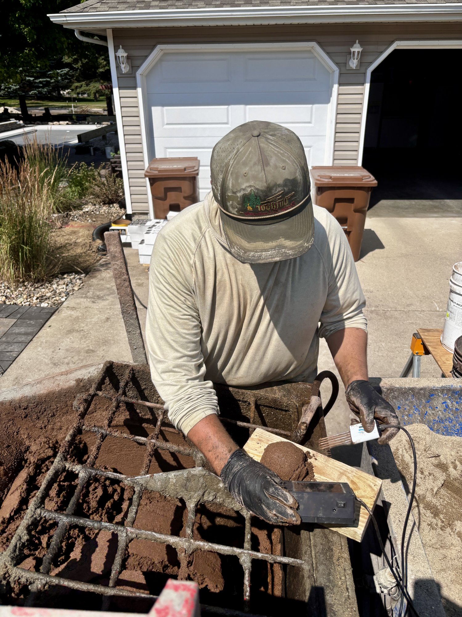 Crew member probing a batch of colored concrete mix with the SlumpMeter sensor